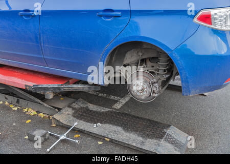 Seasonal tire changing on blue car outdoor closeup Stock Photo