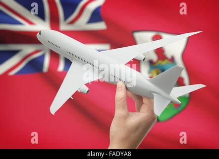 Airplane in hand with national flag on background - Bermuda Stock Photo