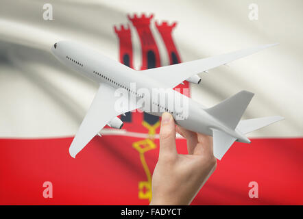Airplane in hand with national flag on background - Gibraltar Stock Photo