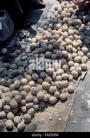 So-called '100-year-old eggs' that are a traditional Chinese delicacy are for sale at a street market in Beijing, capital of the People's Republic of China (PRC). This preserved food is also called a century egg, a hundred-year egg, or a thousand-year egg. Chicken, duck or quail eggs are coated with a clay mixture to keep them from spoiling while they cure for several months before being ready to eat. Once their shells are cracked open, the eggs are visually unappealing because the orange or yellow yolk has turned gray or dark green and the white has become a brown translucent jelly. Stock Photo