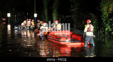 York, UK. 28th December, 2015. Fifteen Fire Fighters from the West Midlands and Northampton Fire and Rescue Services spent four hours in pitch dark last Night to rescue the woman who was stranded at a stables. Crews where called out  to the remote riding stables  just after 4.30. The dramatic footage show the woman in a basket Stretcher being upload from one of specialist rescue team rubber boat.The crews had to  walk in moving flood water shoulder deep in some parts  to rescue the medically sick woman who had been cut off by Flooding in York. Credit:  uknip/Alamy Live News Stock Photo