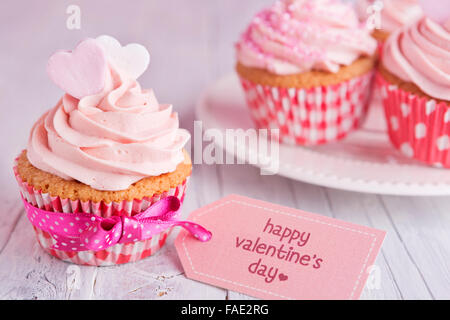 Pink Valentine cupcakes with the words 'Happy Valentine's day' on a tag. Stock Photo