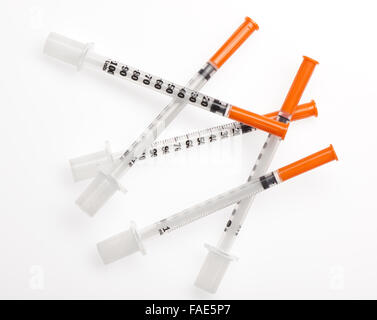 Five plastic syringes with needles closed by protective caps isolated on white background. Clipping path included. Stock Photo