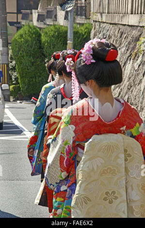 Japanese female tourists on their way to a teahouse and walking down the street dressed for a Maiko Experience in Kyoto Stock Photo