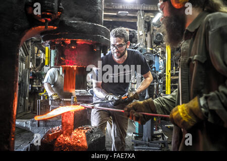 Blacksmith working in forge Stock Photo