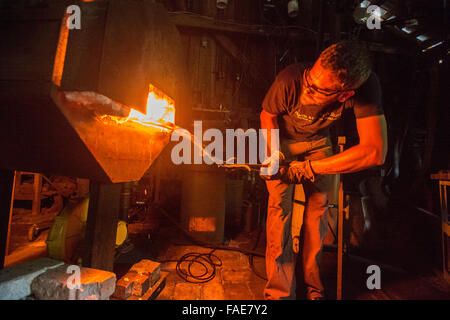 Blacksmith working in forge Stock Photo
