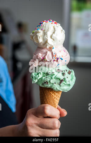 Hand holding a three scooped ice cream cone Stock Photo