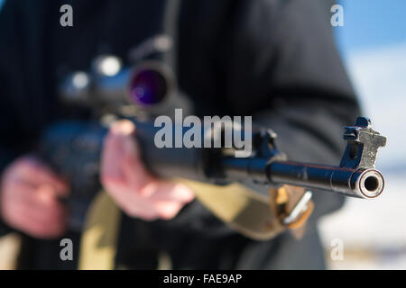 soldier or sniper holding gun with virtual screen projection and aiming in forest Stock Photo