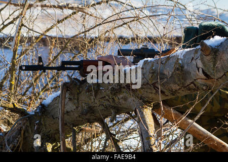 soldier or sniper holding gun with virtual screen projection and aiming in forest Stock Photo