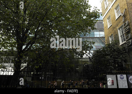 Grey sky view people sitting tables Vibe Bar Courtyard behind metal railings, Old Truman Brewery, Brick Lane, London, E1, UK Stock Photo