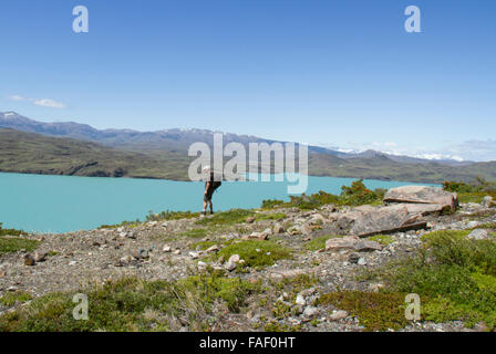 Solitary hiker overlooking Sapphire Lake in Torres del Paine National Park, Patagonia, Chile. Stock Photo