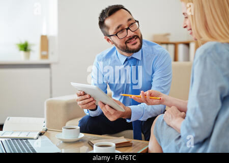 Two business partners using digital tablet during business meeting Stock Photo