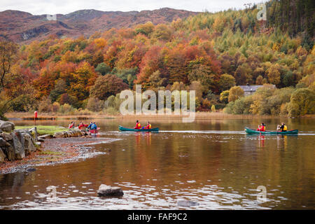 A group of young people paddling Canadian canoes on Llyn Geirionydd lake in Gwydyr Forest Park in Snowdonia in autumn. Wales UK Stock Photo
