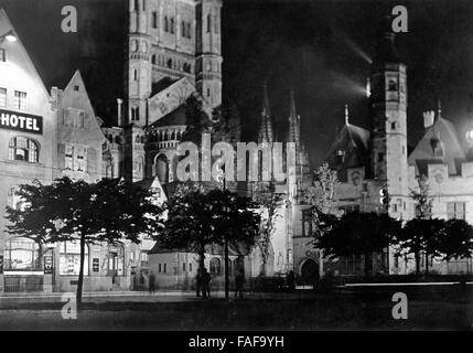 Bei Nacht wird die Kirche Groß St. Martin in der Altstadt von Köln mit Scheinwerfern angestrahlt, Deutschland 1920er Jahre. The church Gross St. Martin's at the old city of Cologne is illuminated by spotlights in the evening, Germany 1920s. Stock Photo