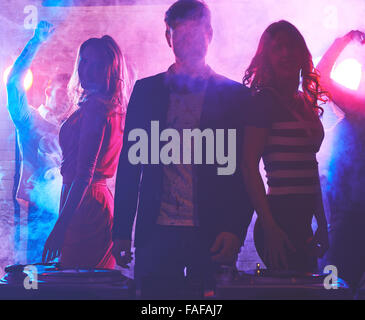 Male dj enjoying party with women behind Stock Photo