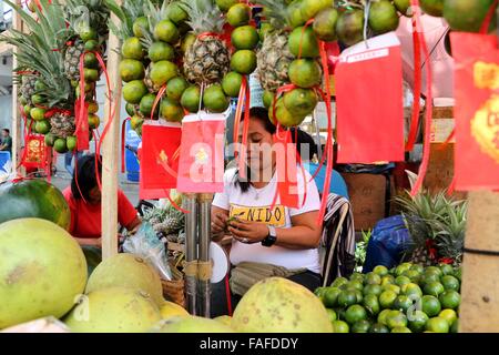 Manila, Philippines. 29th Dec, 2015. A vendor arranges her round fruit product in Manila as for the celebration of coming new year, according to the belief that must prepare 12 round fruits, one for each month of the coming new year to ensure that the new year being welcomed is a prosperous one. Many of these superstitions bear a strong Chinese influence. © Gregorio B. Dantes Jr./Pacific Press/Alamy Live News Stock Photo