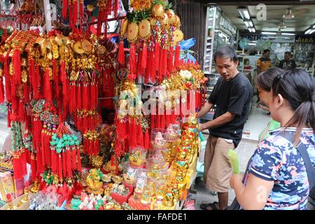 Manila, Philippines. 29th Dec, 2015. A market goers buy a lucky charm in the street of Manila as part of the celebration to welcome the 2016 new year, this traditions was influences by the Chinese tradition to the Filipino culture to ensure that the new year being welcomed is a prosperous one. © Gregorio B. Dantes Jr./Pacific Press/Alamy Live News Stock Photo