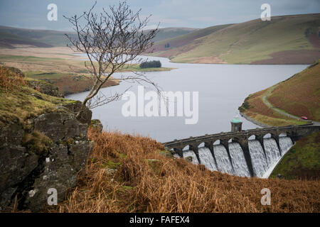 Water overflowing spilling over Craig Goch dam and reservoir, Elan Valley water system, designed to provide a secure supply of fresh water , supplied by a gravity fed aqueduct to the city of Birmingham, some 70 miles to the east. December Winter day, Powys Mid Wales, UK Stock Photo