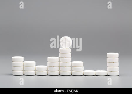 Abstract chart of white pills on a gray background Stock Photo