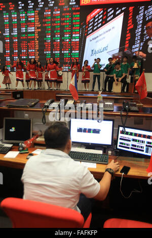 Makati City, Philippines. 29th Dec, 2015. A trader continues to work as children sing and dance during the last trading day of 2015 at the Philippine Stock Exchange(PSE) in the financial district of Makati, south of Manila, Philippines, Dec. 29, 2015. Credit:  Rouelle Umali/Xinhua/Alamy Live News Stock Photo