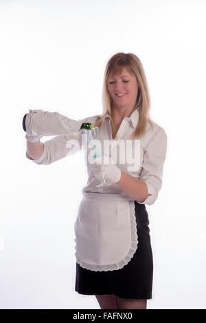 Waitress wearing white cotton gloves pouring sparkling wine from a green bottle Stock Photo