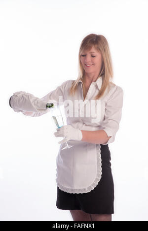 Waitress wearing white cotton gloves pouring sparkling wine from a green bottle Stock Photo