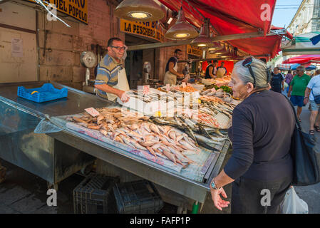 Fish market Sicily, in the fish market at Ortigia (Ortygia) a senior Sicilian woman looks at a display of fresh fish, Syracuse (Siracusa), Sicily. Stock Photo