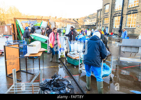 Hebden Bridge, UK. 29th Dec, 2015. School furniture, books and equipment, destroyed in the Hebden Bridge Boxing Day floods,  are piled up in the Riverside Junior School playground, while volunteers load it into skips and vans. Credit:  Graham Hardy/Alamy Live News Stock Photo