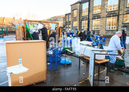 Hebden Bridge, UK. 29th Dec, 2015. School furniture, books and equipment, destroyed in the Hebden Bridge Boxing Day floods,  are piled up in the Riverside Junior School playground, while volunteers load it into skips and vans. Credit:  Graham Hardy/Alamy Live News Stock Photo