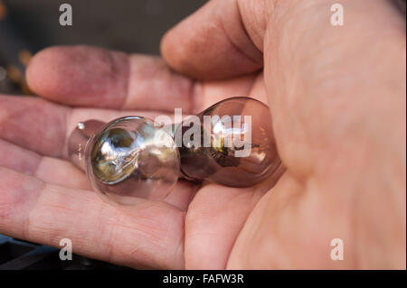 burnt out filament bulb showing silvering and blackening compared to replacement new clean car rear light tail gate Stock Photo