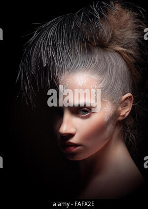 Beautiful woman with  feather. Art make-up. Stock Photo