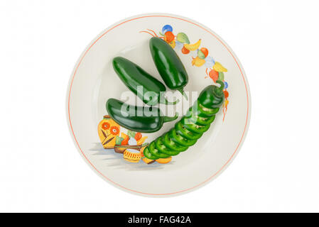 Four Green Jalapeno Peppers on a Colorful, Festive, Antique Fiesta Plate, one Sliced Green Jalapeno stacked in pepper shape. Stock Photo