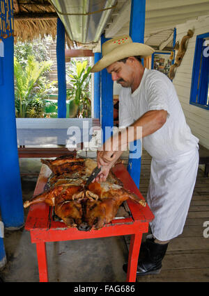 Man carving roast pig, Pinar del Rio, Cuba Stock Photo