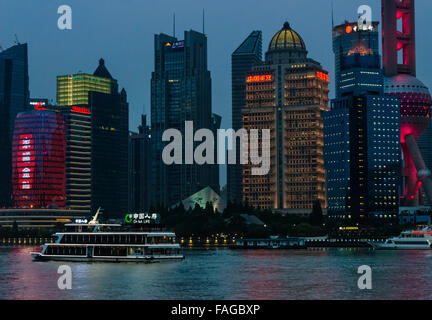 High rises in Pudong and cruise ship on Huangpu River at dusk, Shanghai, China Stock Photo