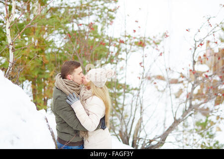 Young couple kissing in winter park Stock Photo