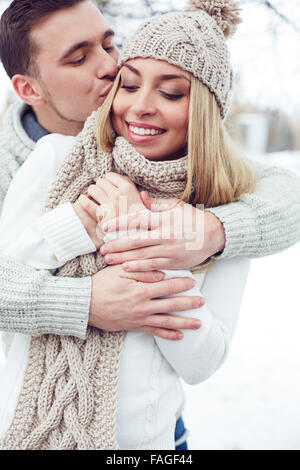 Young man embracing and kissing his girlfriend Stock Photo