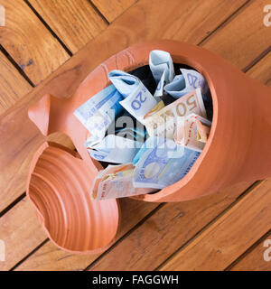Euro notes in broken clay piggy bank Stock Photo