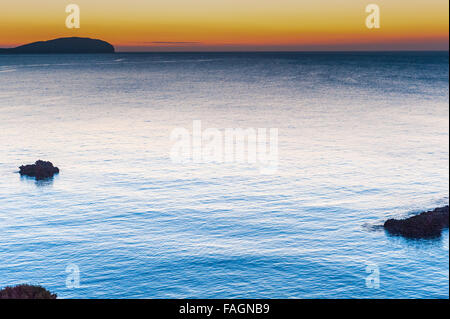 Sunrise over the calm beautiful water in Es Canar, Ibiza, part of the Balearic Islands in Spain,Europe. Stock Photo