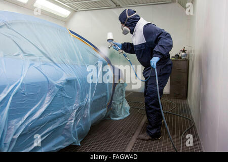 Vehicle varnisher in the paint spraying cabin. Stock Photo
