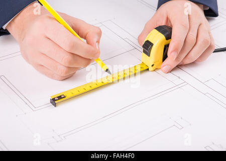 Male hands drawing a building plan. Stock Photo