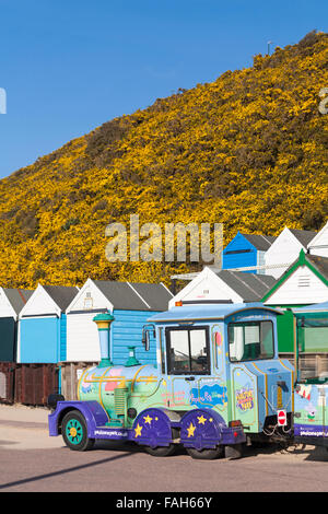 The home of Peppa Pig world - Landtrain on the promenade at Middle Chine, Bournemouth with beach huts in April Stock Photo