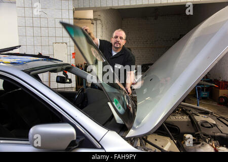 Replace the windscreen in an auto glass workshop. Stock Photo