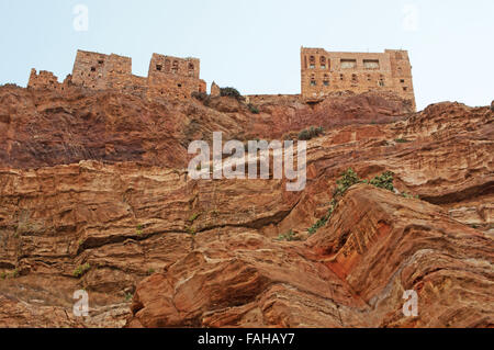 Yemen: red rocks and decorated old houses built on the top of a mountain in the perched city of Kawkaban,  fortified city northwest of Sana’a Stock Photo