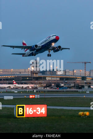A passenger aircraft of British Airways is taking off runway 34 of Zurich international airport into the evening twilight. Stock Photo