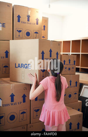 Child stacking house moving boxes Stock Photo