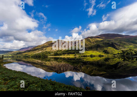 Lake Buttermere reflecting the surrounding hills on a bright sunny early autumn day Stock Photo