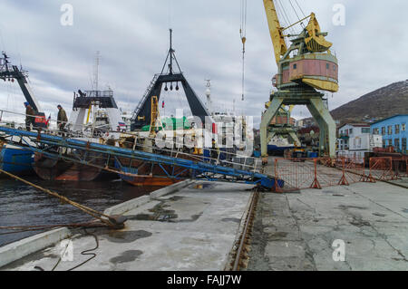 Mooring fishing trawlers and an old crane at the port of Petropavlovsk-Kamchatskiy, Kamchatka, Russia. Stock Photo