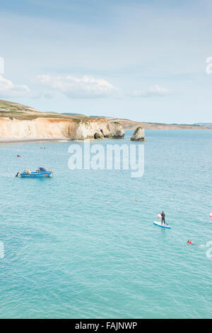 The beach and cliffs at Freshwater Bay Isle of Wight UK with people in the water paddleboarding Stock Photo