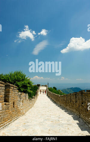 three people walking along a section of the Great Wall, Jinshanling, China. Stock Photo