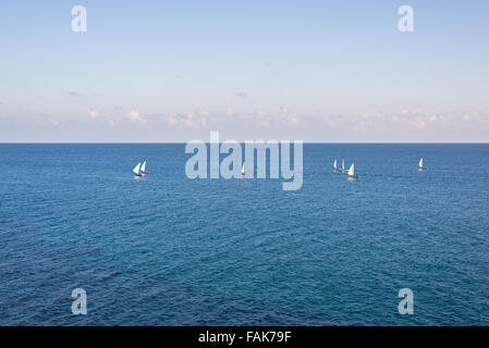 Group of sailing boats on the blue Mediterranean Sea. Ship yachts with white sails in the open sea. Concept of luxury lifestyle Stock Photo